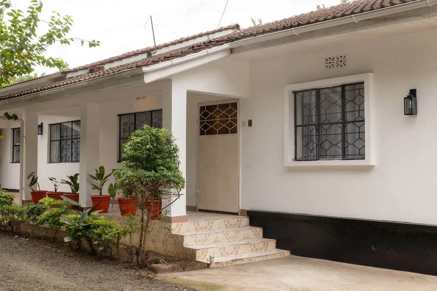 Covered veranda and house exterior with potted plants