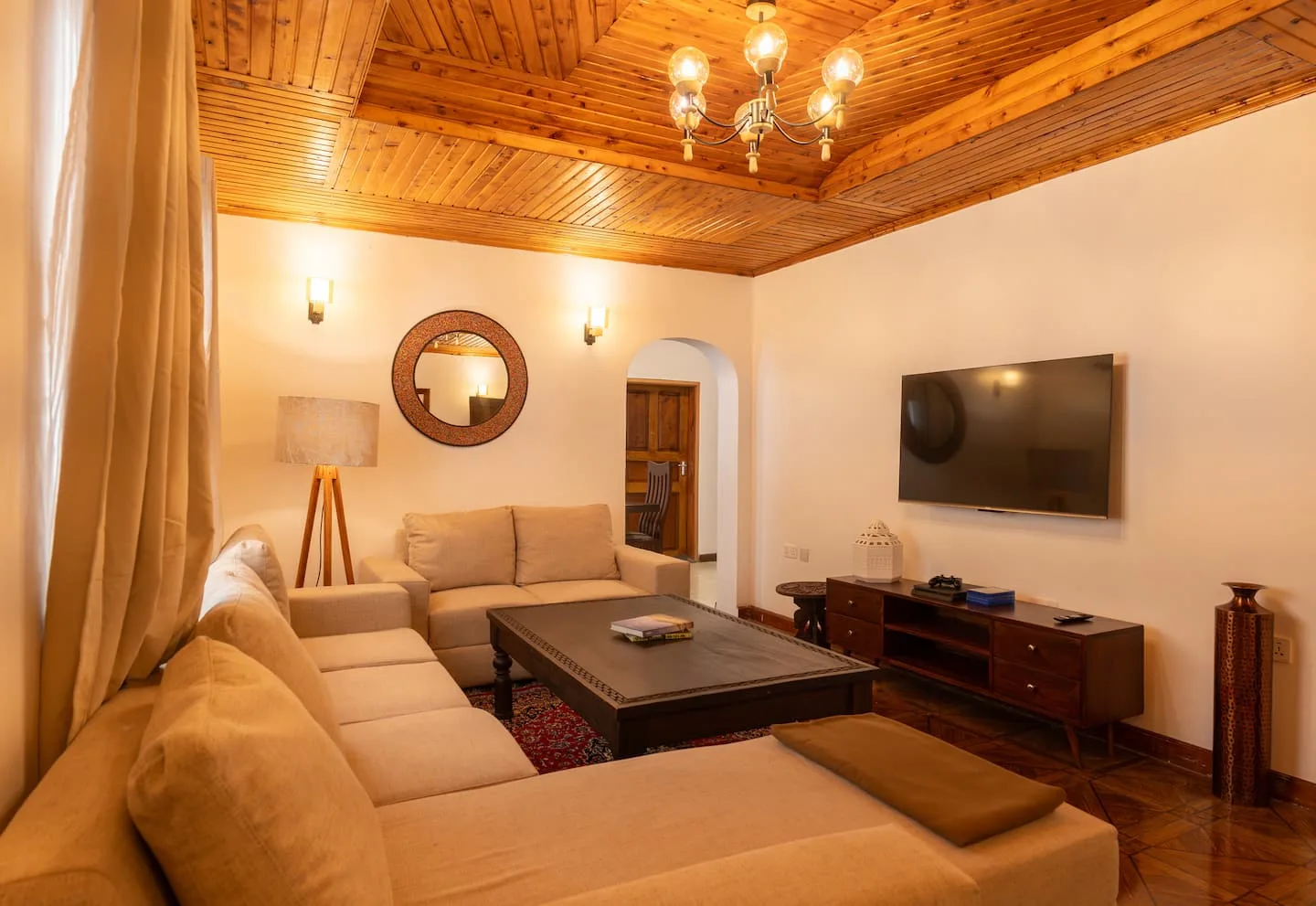 Warm living room with a wood-beamed ceiling and soft sofas at Home Sweet Hideaway
